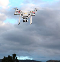 drone with camera flying with clouds behind it