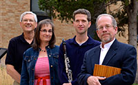 three men and one woman standing with a clarinet and a wooden flute