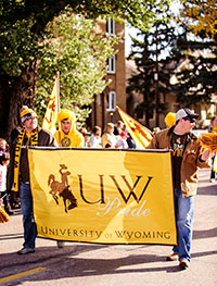 people carrying a University of Wyoming banner in a parade