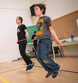 a girl and a boy jumping rope