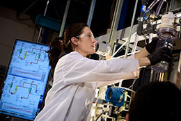 woman working with lab equipment with a computer display in the background