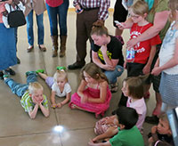 children clustered around a shining spot on the floor