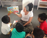 woman reading to several small children