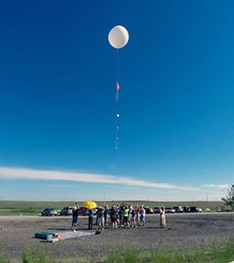 people watching a weather balloon ascend