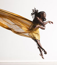 dancer soaring through the air with filmy clothing streaming behind