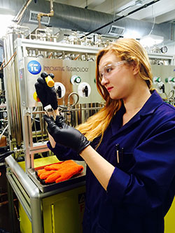 woman holding equipment in gloved hands in chemistry lab
