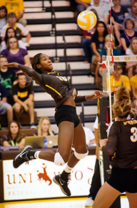 woman in mid jump, preparing to hit the volleyball very hard