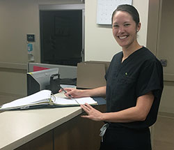 woman in scrubs standing at counter
