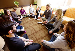 people sitting on the floor in a group, eyes closed