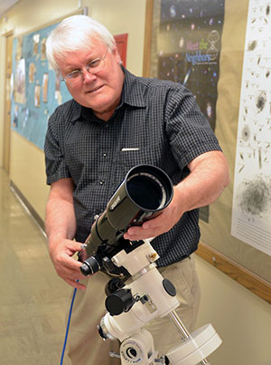 man standing with small telescope in hallway