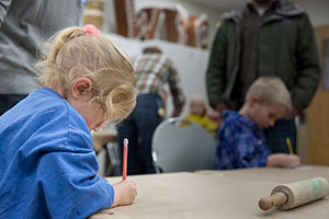child with pencil at table