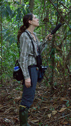 woman standing in lush forest with large microphone
