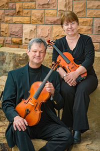 man and woman holding string instruments