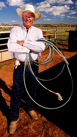 man standing in a corral with a lasso in his hands