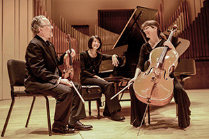 three people seated with musical instruments