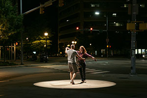 two people dancing outside in the dark