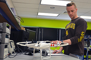 man at a lab table with a drone and other equipment