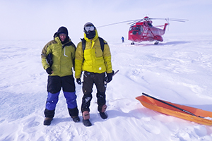 Two men stand on the Greenland Ice Sheet.