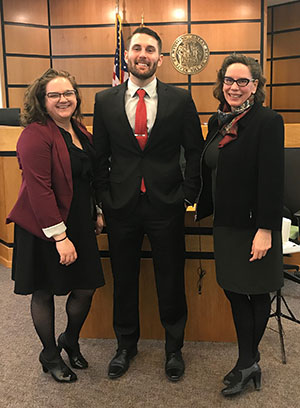 Two women and a man standing together