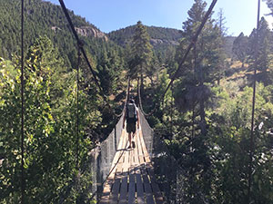person crossing a suspended bridge