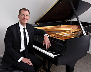man sitting at a grand piano