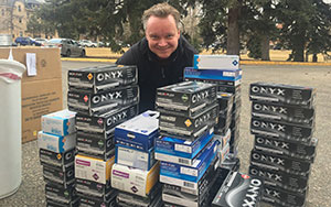 man standing behind a stack of boxes of gloves
