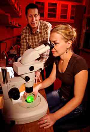 man and woman with microscope