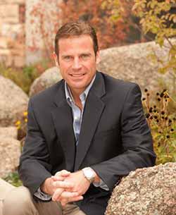 man sitting amid boulders