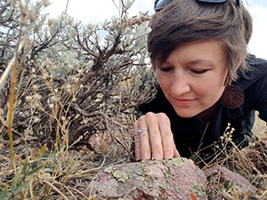 woman examining plants on the ground