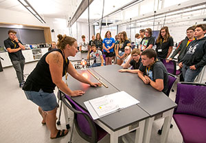 group of teens watching an adult demonstrate something
