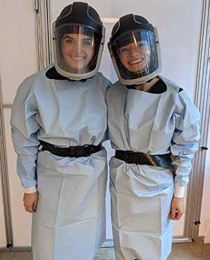 two women standing together in protective gear