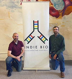 two people kneeling beside a sign
