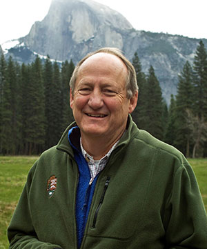 man standing outside with mountains in background