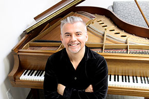 man sitting by a piano