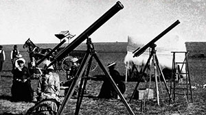 vintage photo of telescopes lined up with people using them 
