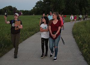 people walking through a park in the evening