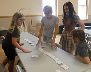 four people looking at index cards spread out on a table