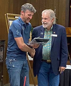 man getting an award from another man