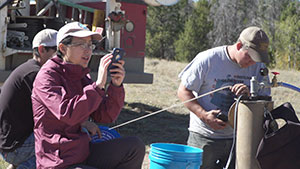 three people working in the field with equipment