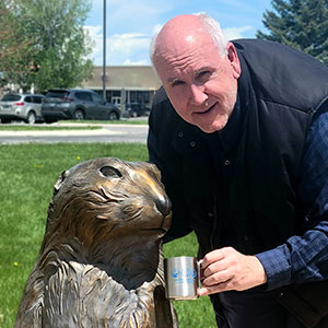 man with a statue of a groundhog