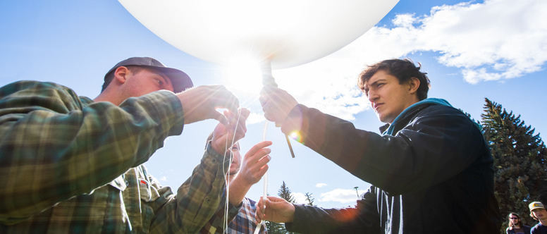 Two students work with a weather balloon