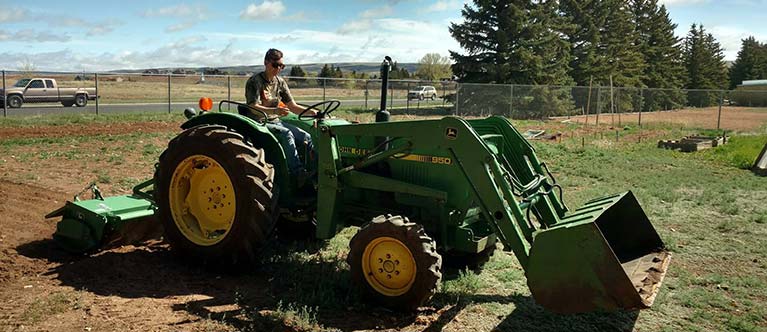 student driving a tractor