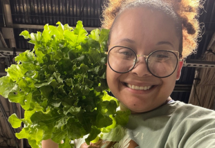 student holding lettuce grown for NASA research