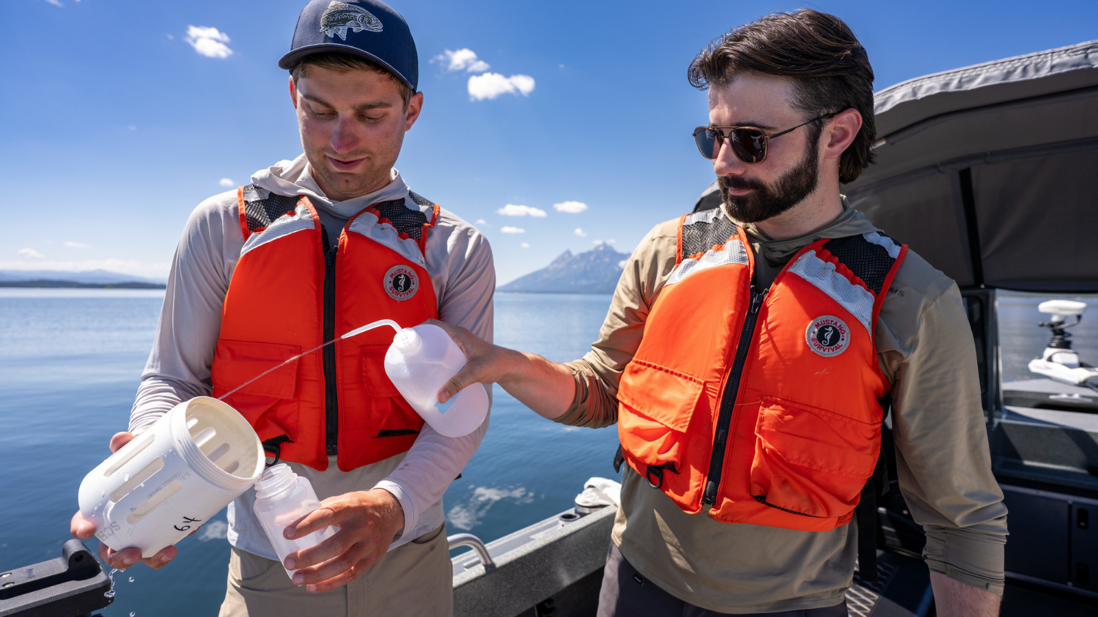 Two students working on a small boat, in a lake collecting data
