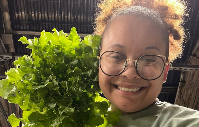Undergraduate student holding a head of lettuce