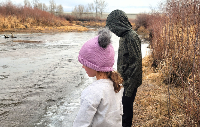 Two children playing by a riverbank