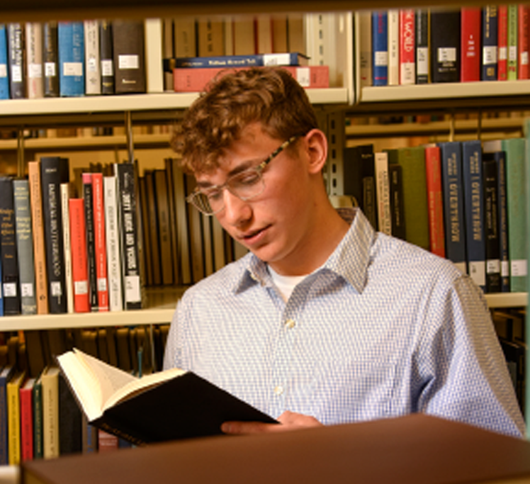 student reading a book in the library