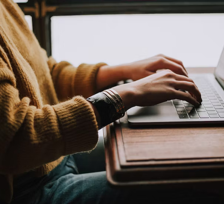 student typing at computer