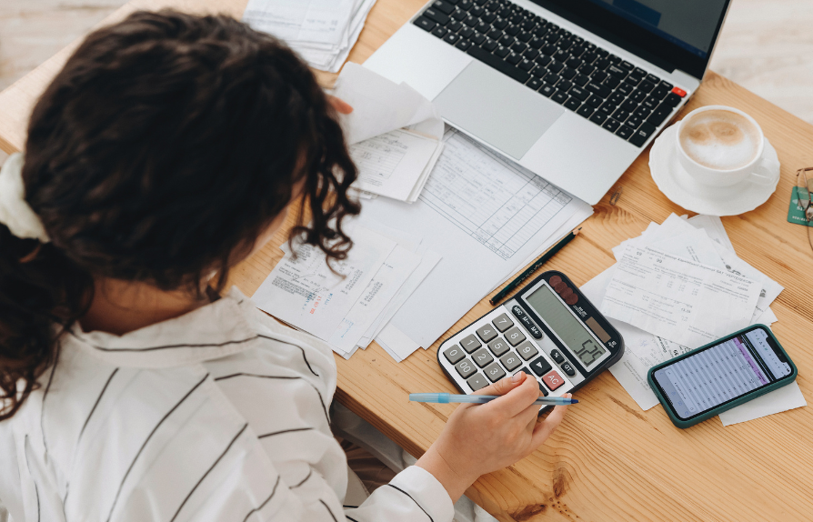 over the shoulder of a person looking at paper scattered on a table top