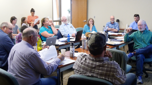 a group of people around a conferene table in a meeting